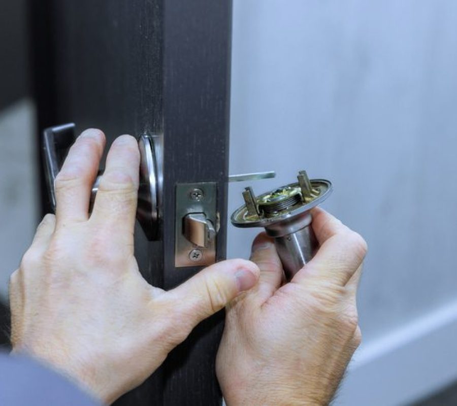 Mechanic installs lock handles on room doors